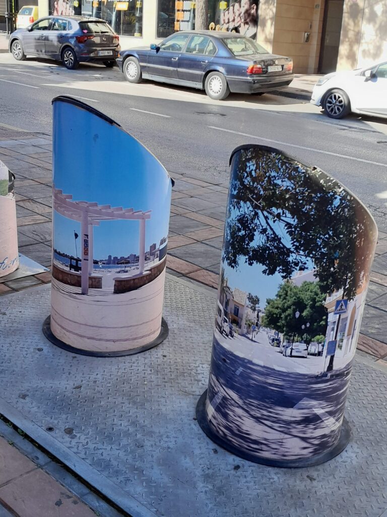Maalatut roskatornit lähikuvassa. Toisessa näkymä rantakadulta ja toisessa katunäkymä puineen ja autoineen. Fuengirola - suomalainen paratiisi Espanjassa on myös taidetta!