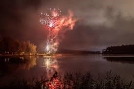 Iltayössä kokko roihuaa meren rannassa.